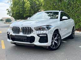 a white bmw x6 standing on a road